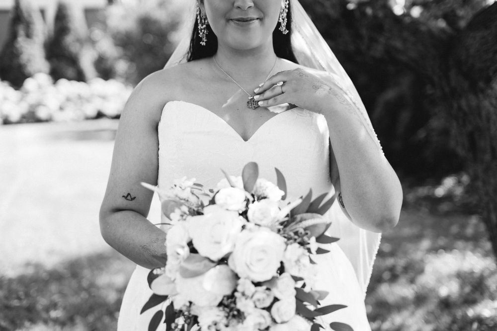 Black and white portraits of a bride holding a white bouquet on her wedding day.