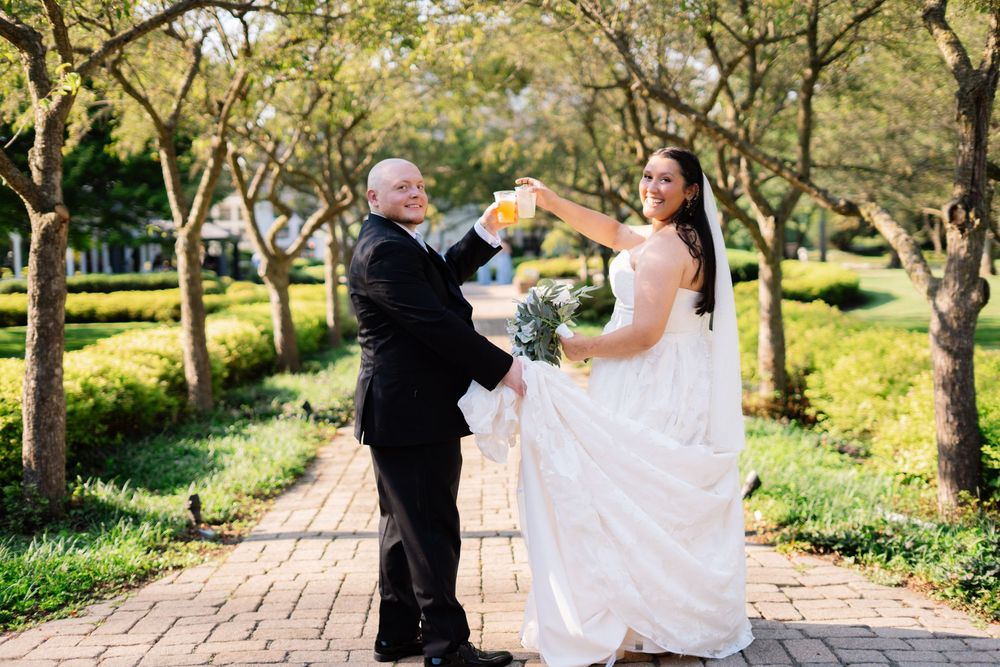 Couple walking along a tree-lined path during their wedding photoshoot.