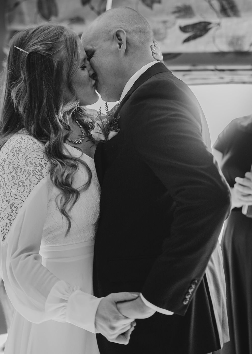 Black and white wedding photos showing tender moments between newlyweds in elegant attire.
