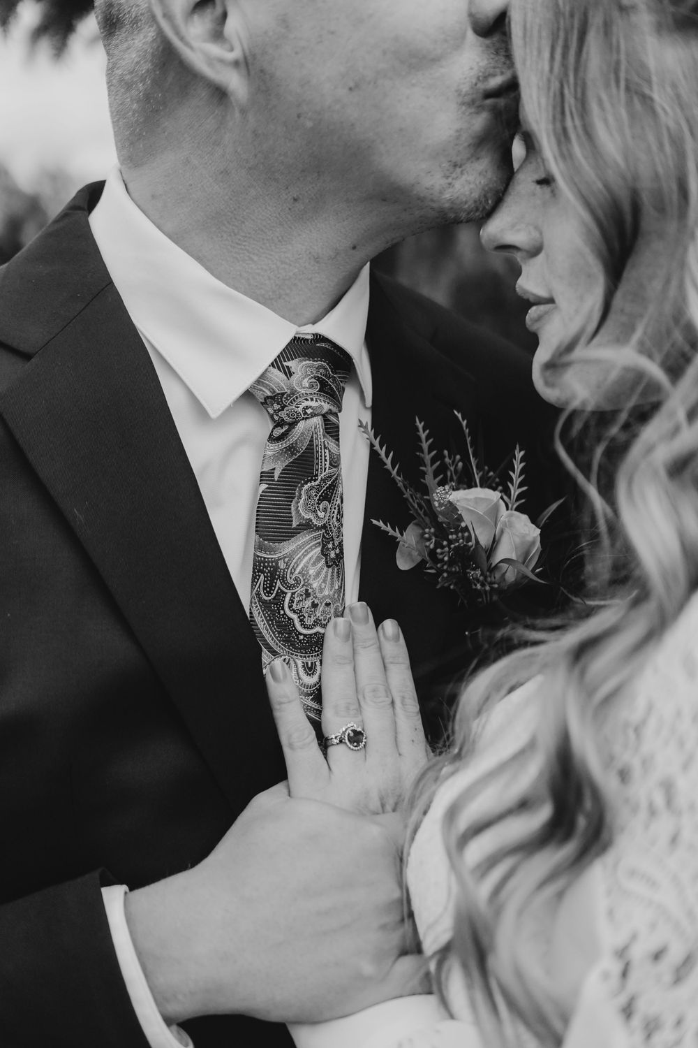 Black and white romantic close-up photos of a couple sharing intimate kisses during their wedding ceremony.