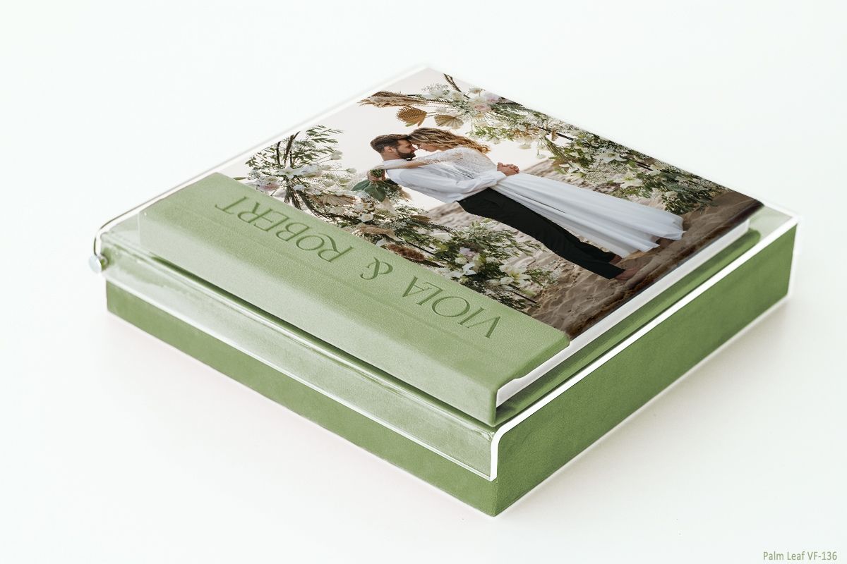 Luxury sage green photo album with embossed cover displaying a wedding photograph.