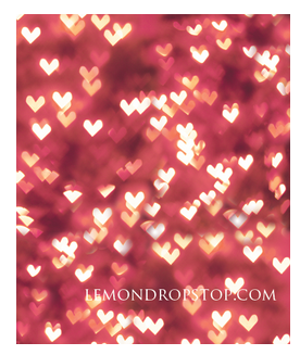 Romantic bokeh background with heart-shaped lights in red and gold tones for Valentine's Day.