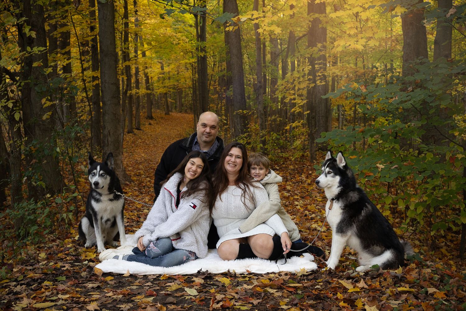 Family portrait session outdoors with blue dress and casual attire.