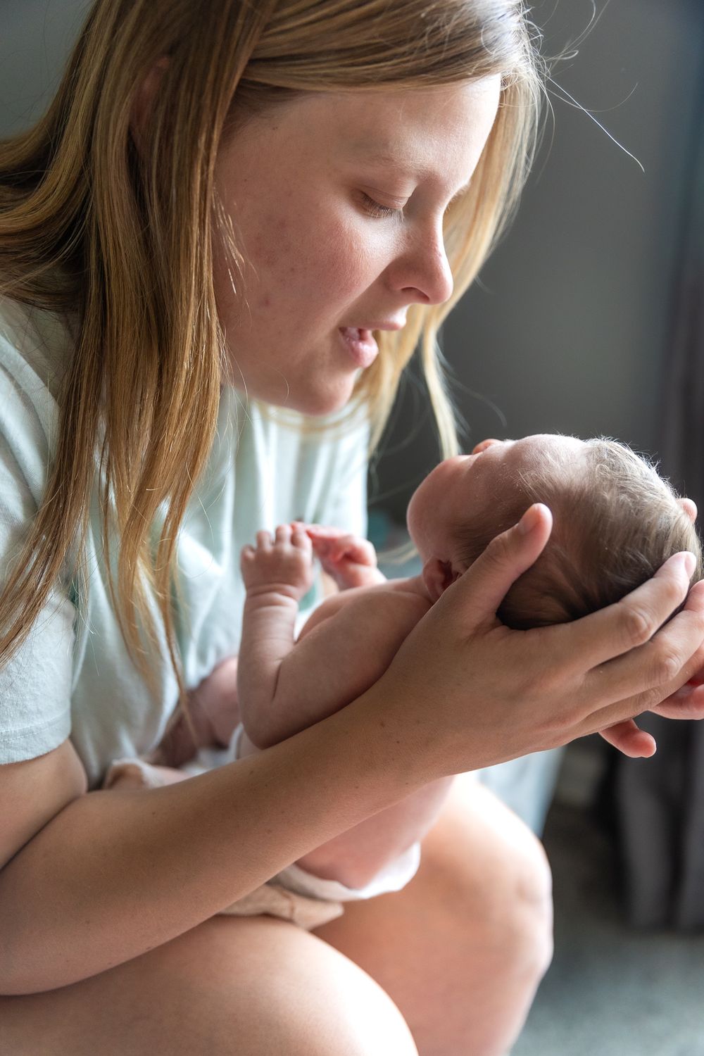 A tender moment as someone cradles a newborn baby with gentle care.