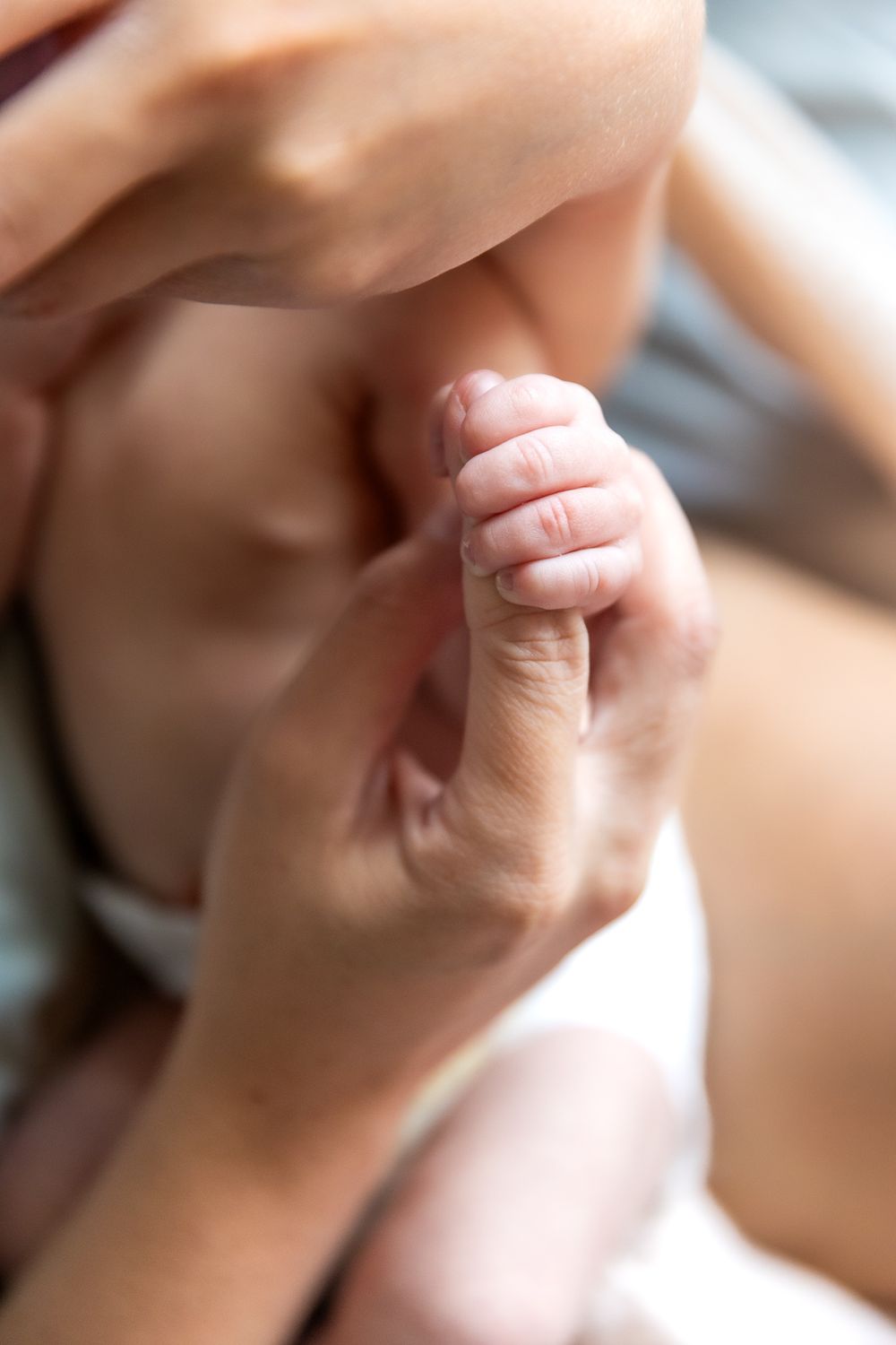 Close-up shot of a tiny newborn baby's hand being held.