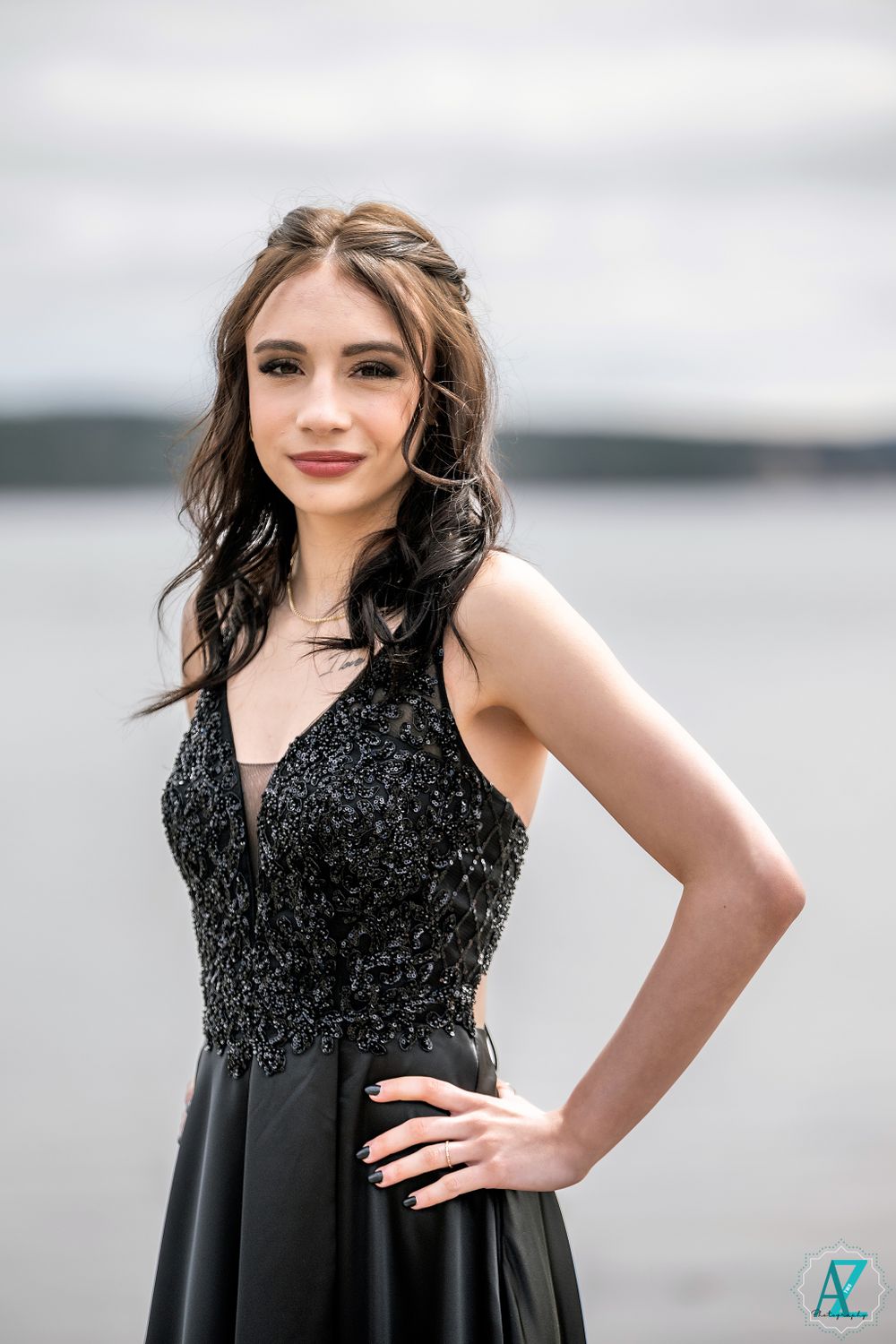 Elegant formal portrait by a lake wearing a black sequined evening gown.