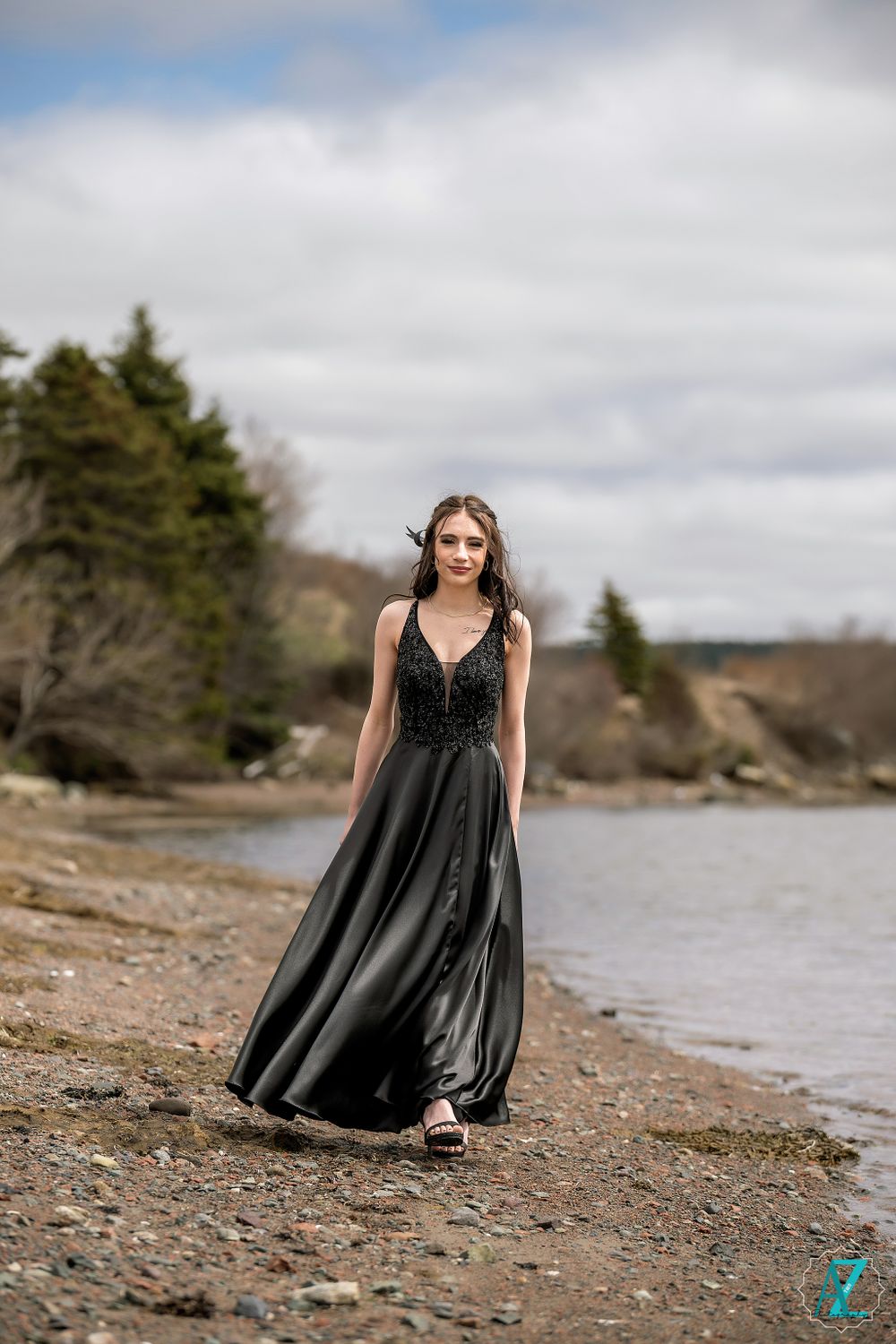 An elegant black evening gown photo on a scenic rocky shoreline.