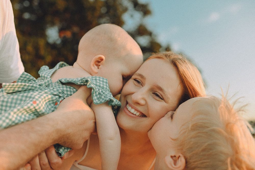 A joyful outdoor family moment captured in warm sunlight.