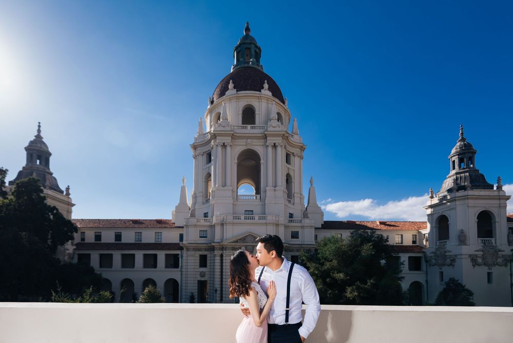 A couple standing before the majestic Pasadena City Hall with its iconic dome.