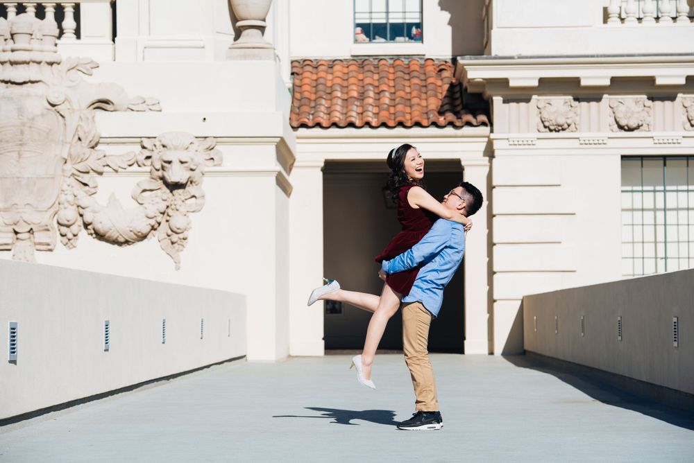 A playful lift pose against a classical architecture backdrop.