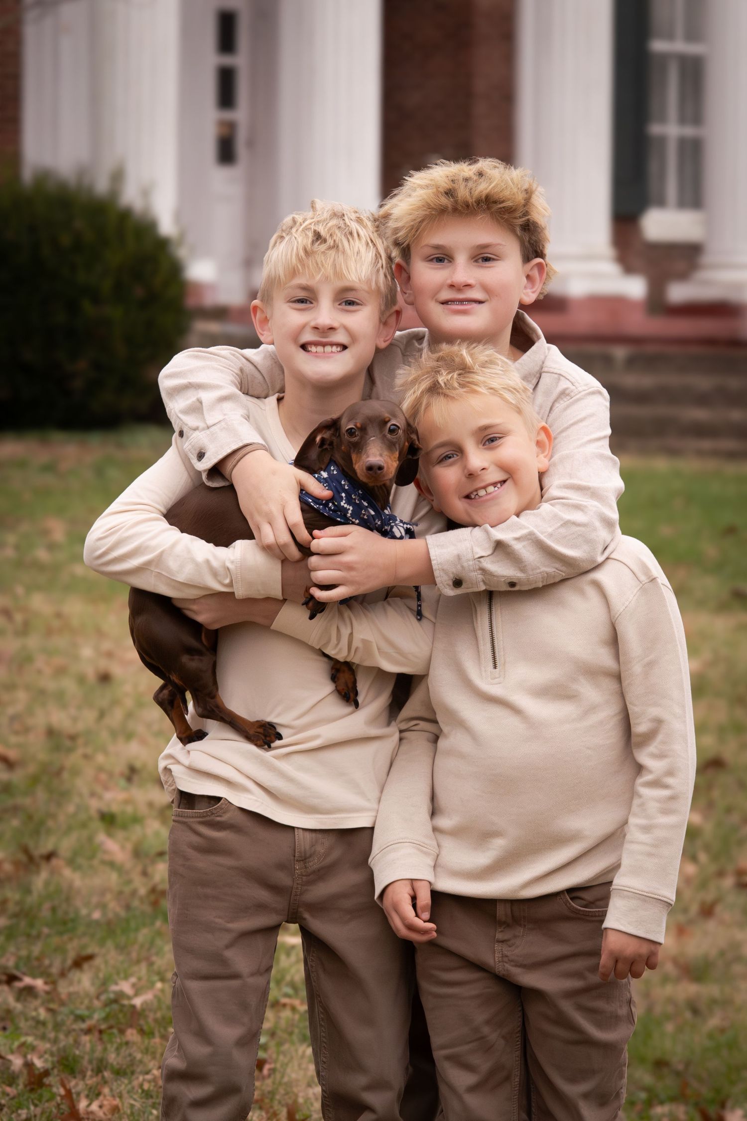 Three children in matching beige outfits play and hug together outdoors in a series of candid photos.