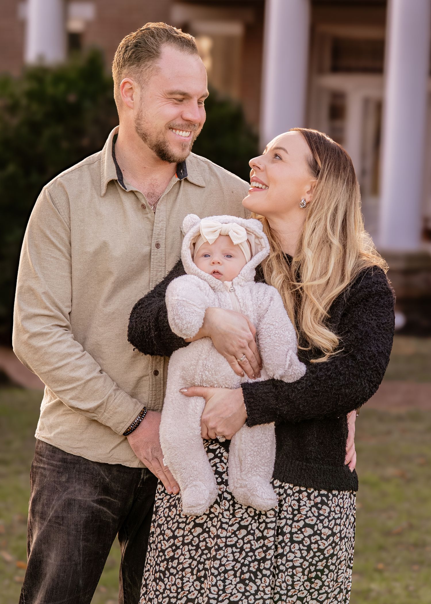 A couple shares tender moments with their baby outdoors in a series of candid family portraits.