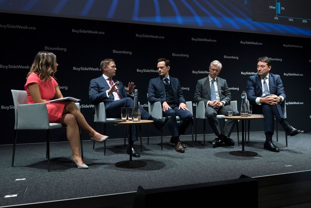 Panel discussion at Bloomberg BuySlideWeek event with four executives on stage being interviewed by a moderator.