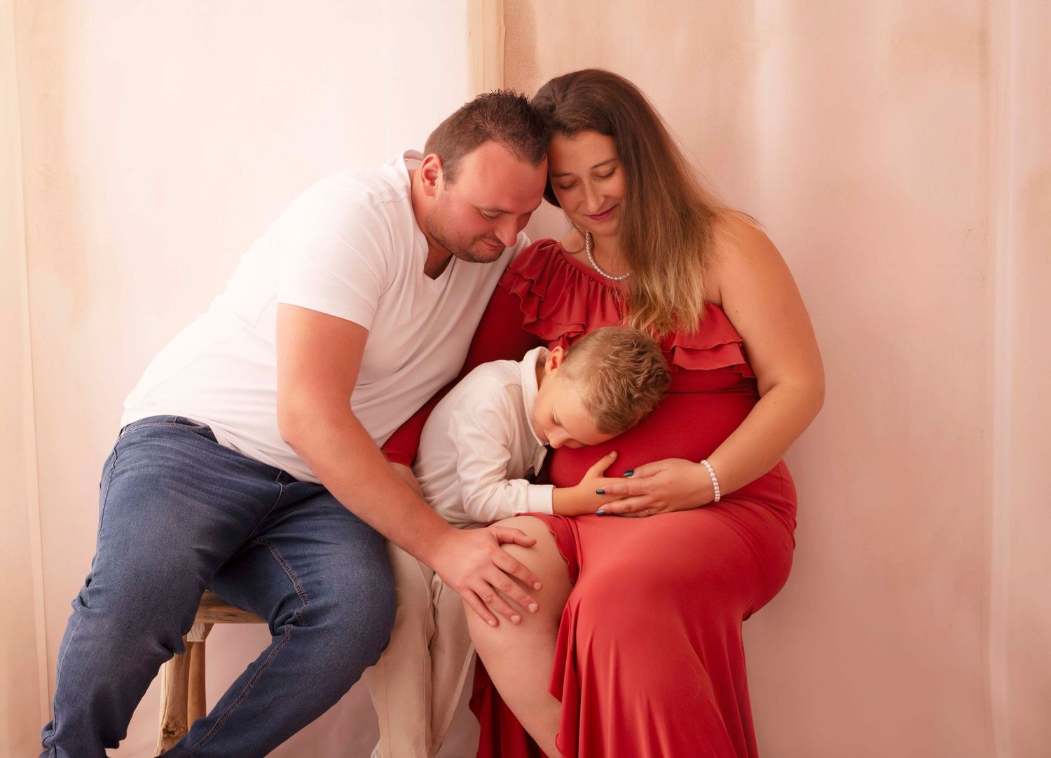 Baby sitting with cake during messy cake smash photo session against white background.
