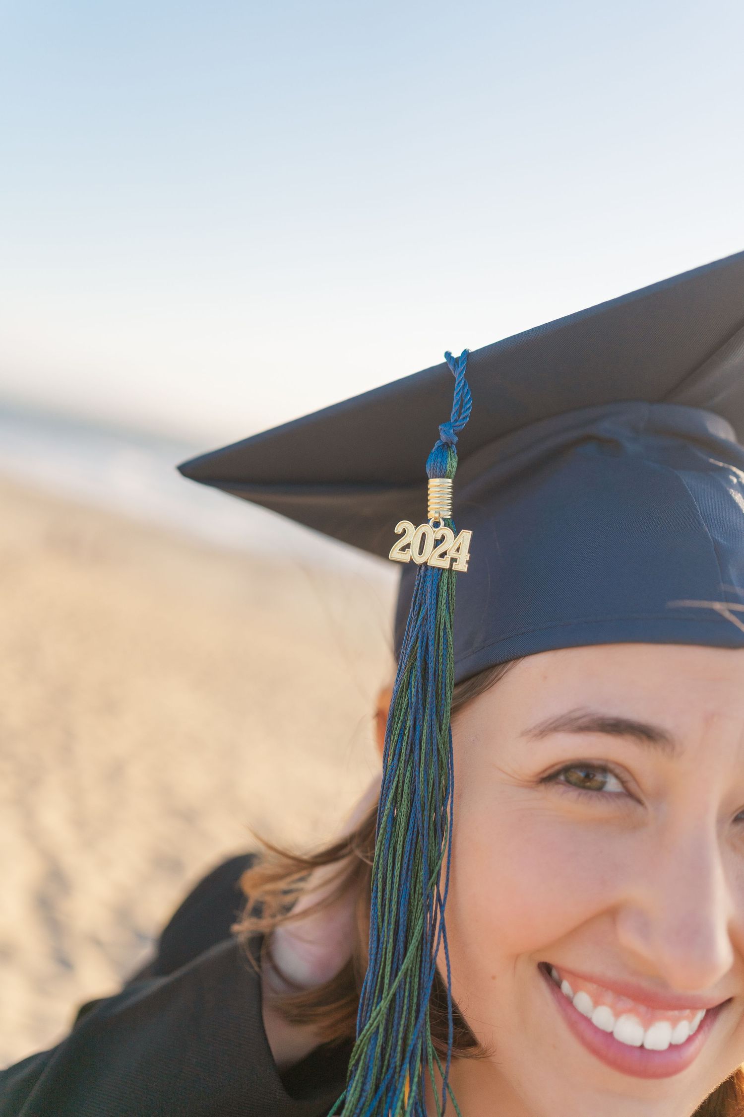 A graduation cap with a 2021 tassel worn during an outdoor ceremony with sunny blue skies.