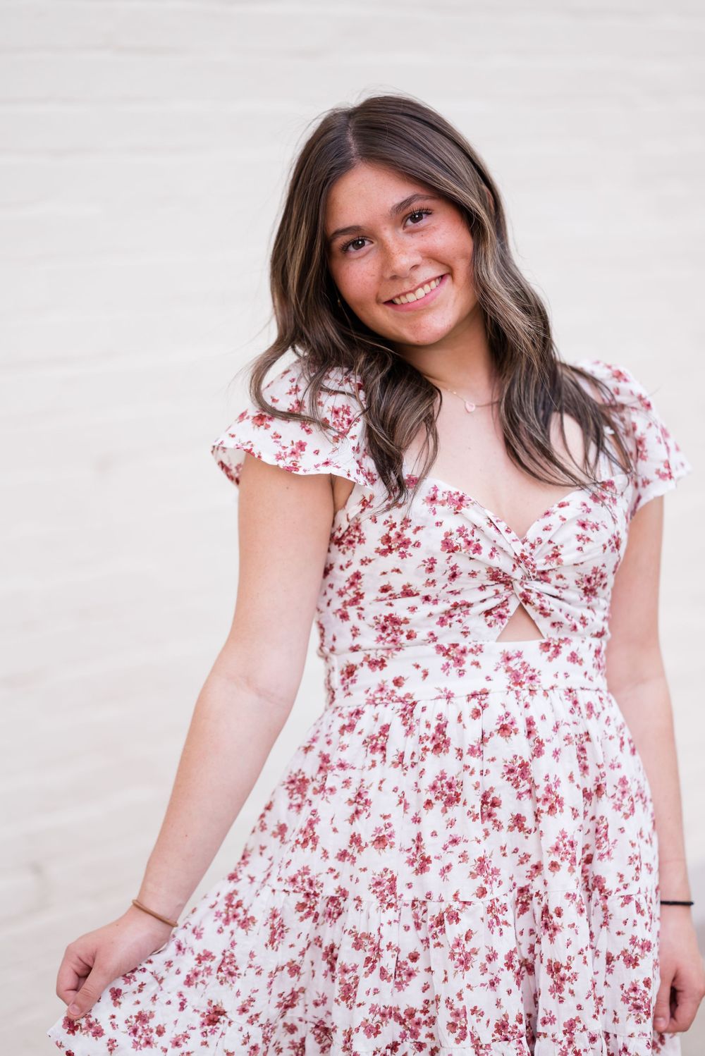 A floral white and red dress is modeled in a series of close-up shots against a light background.