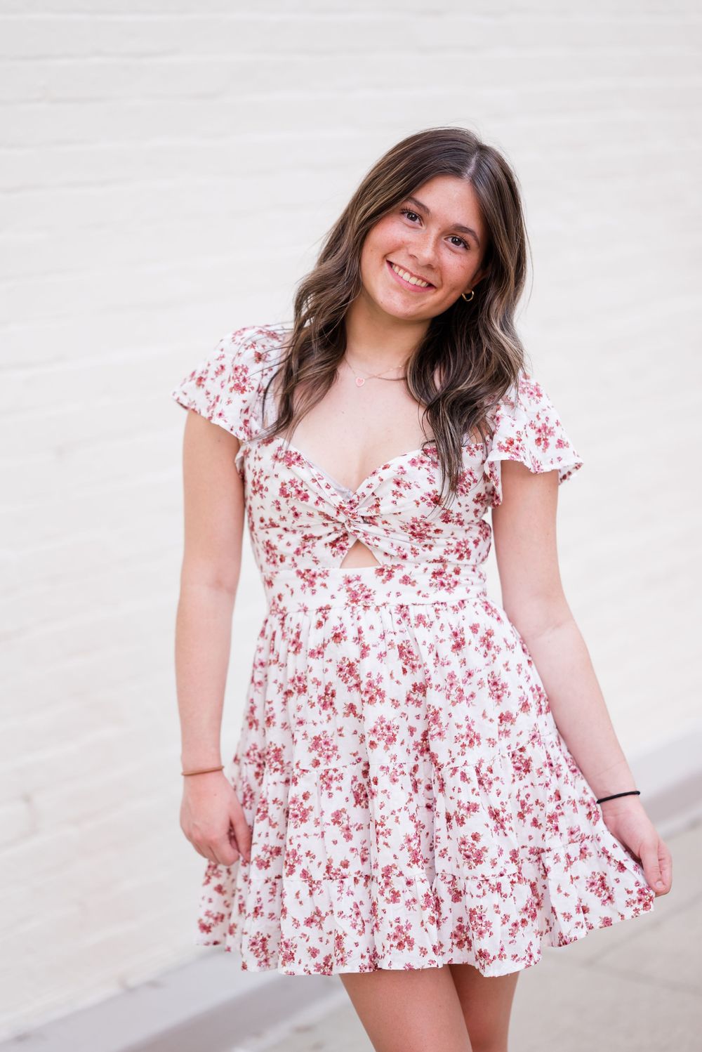 Multiple poses in a white and red floral dress against a light background.