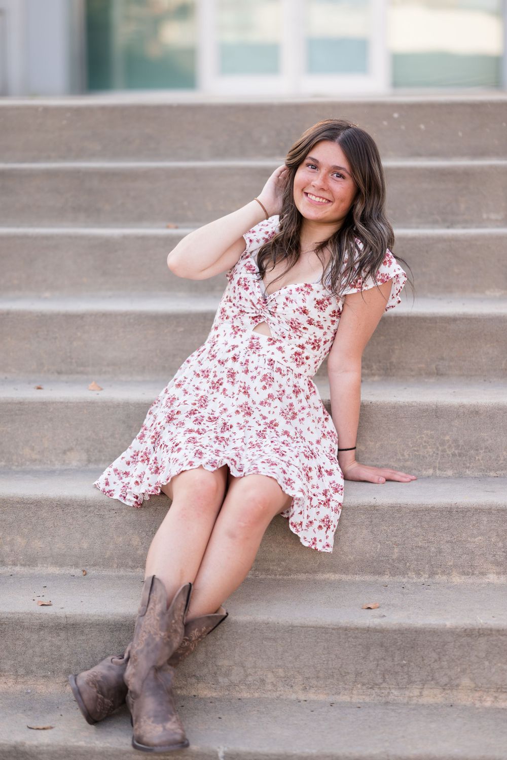 Casual fashion portraits on concrete steps featuring a floral dress and brown boots.
