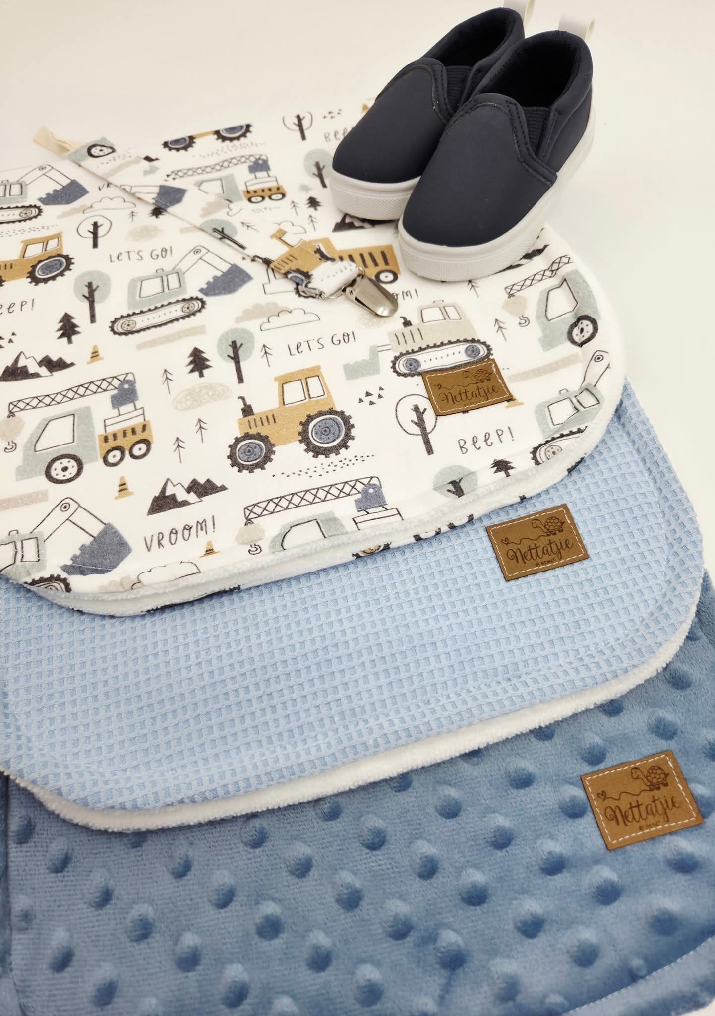 Construction vehicle pattern burp cloth with blue minky fabric and navy slip-on shoes.