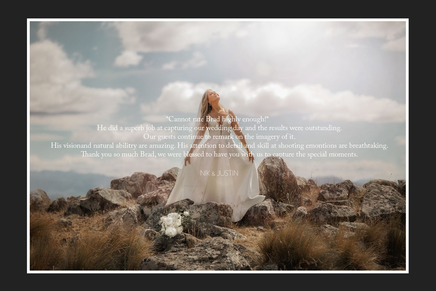 A bride in a flowing white dress stands on rocky terrain against cloudy skies.