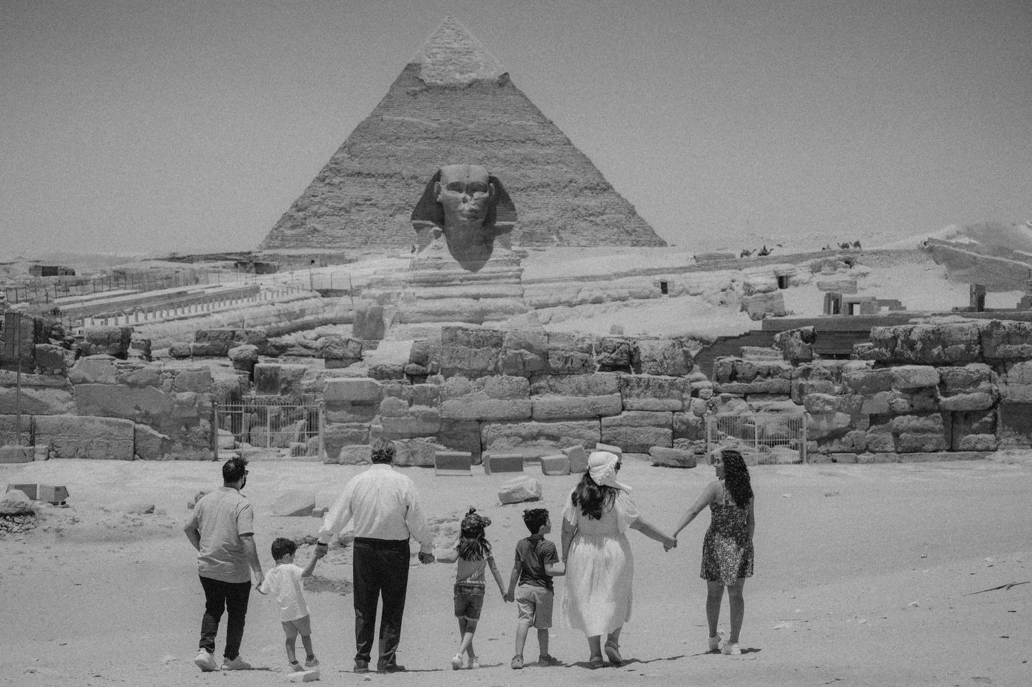 Group walking together towards the Great Pyramid of Giza in a black and white vintage photograph.