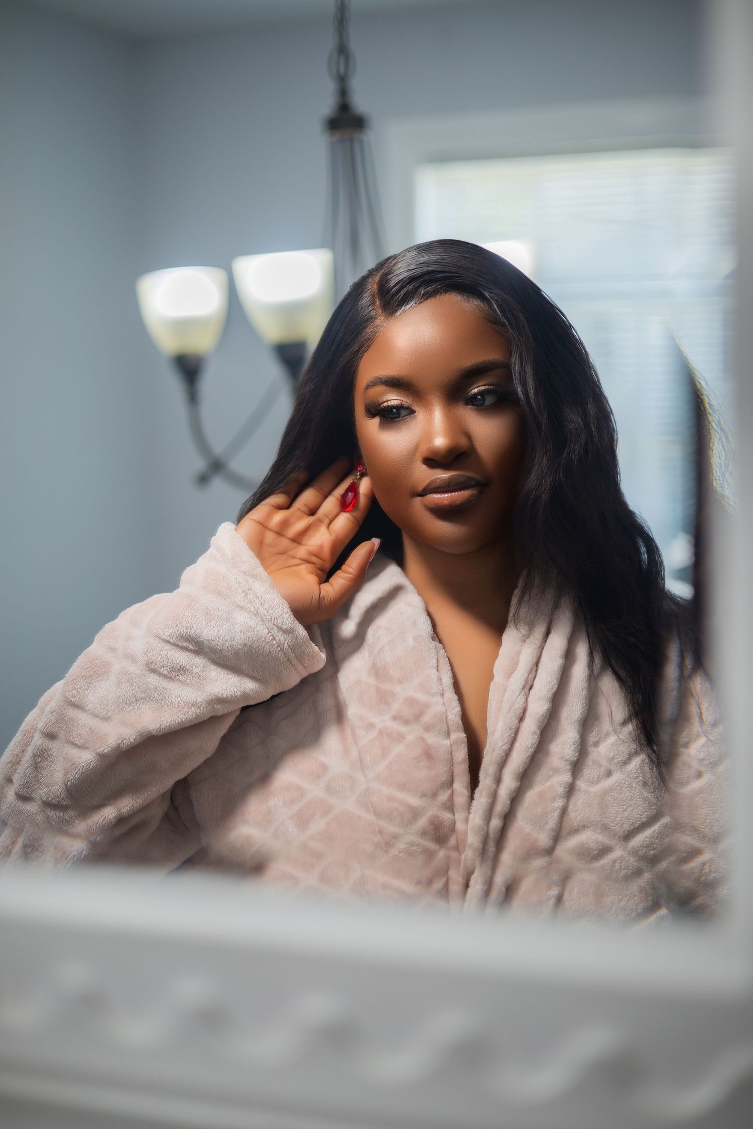 Soft bathroom self-care portrait in cozy robe with ambient lighting.