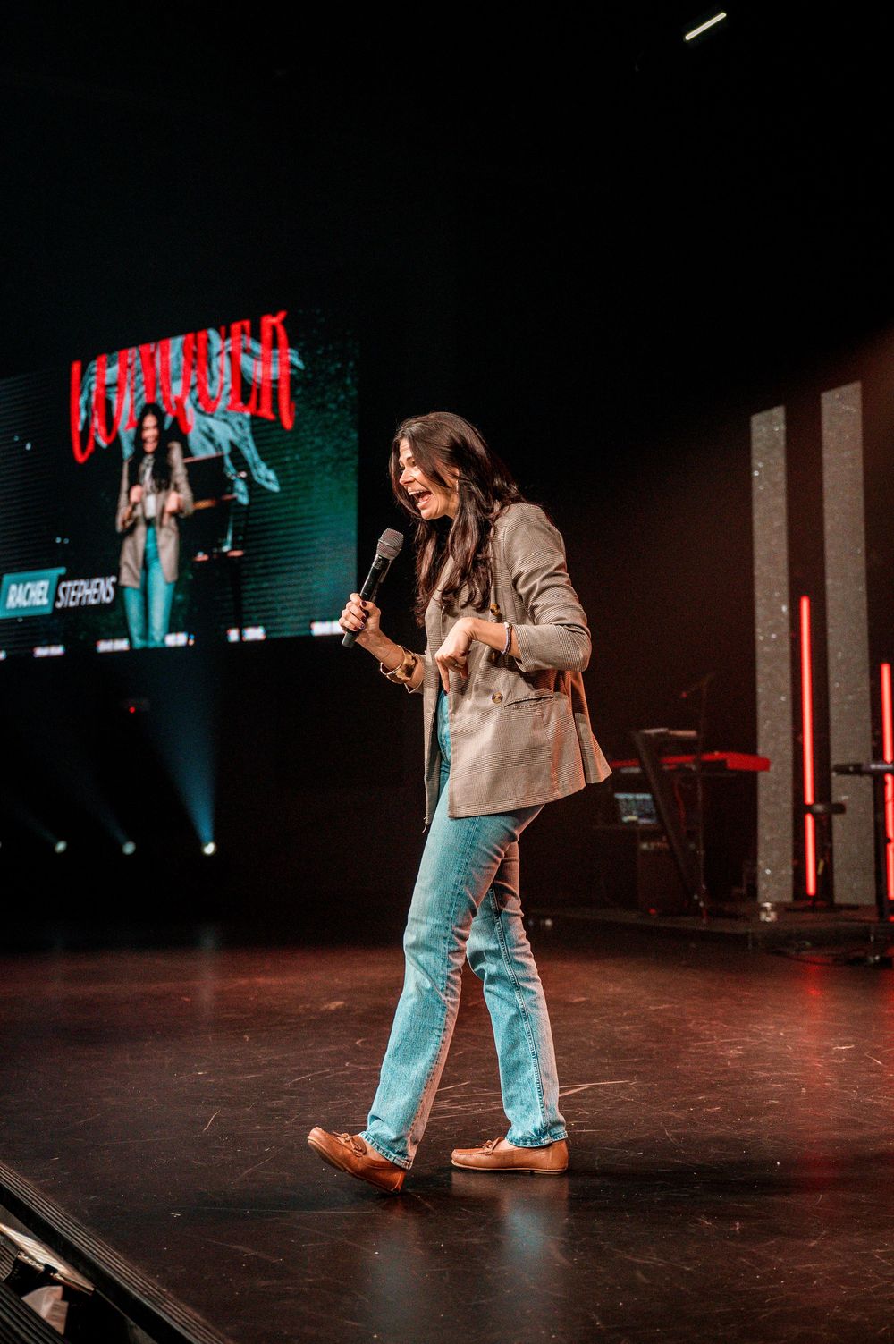 A sequence of dance moves captured in low light on a dark stage with neon accents in the background.