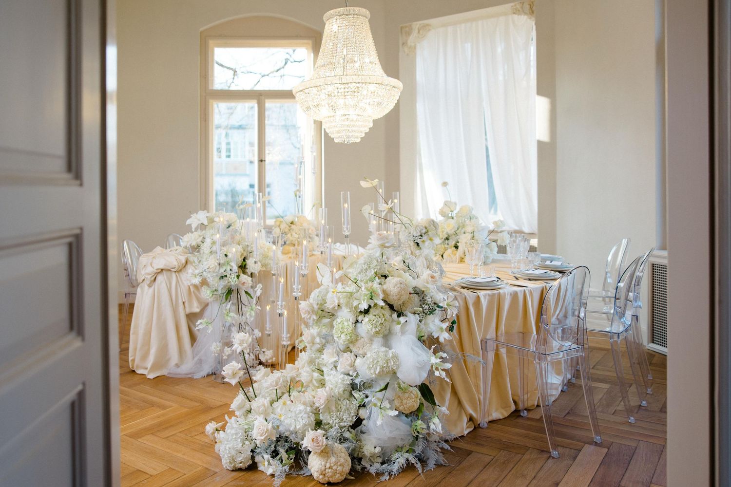 Elegant wedding reception setup with crystal chandeliers and white floral centerpieces. Organized wedding by MyCastleWedding | Dresden.