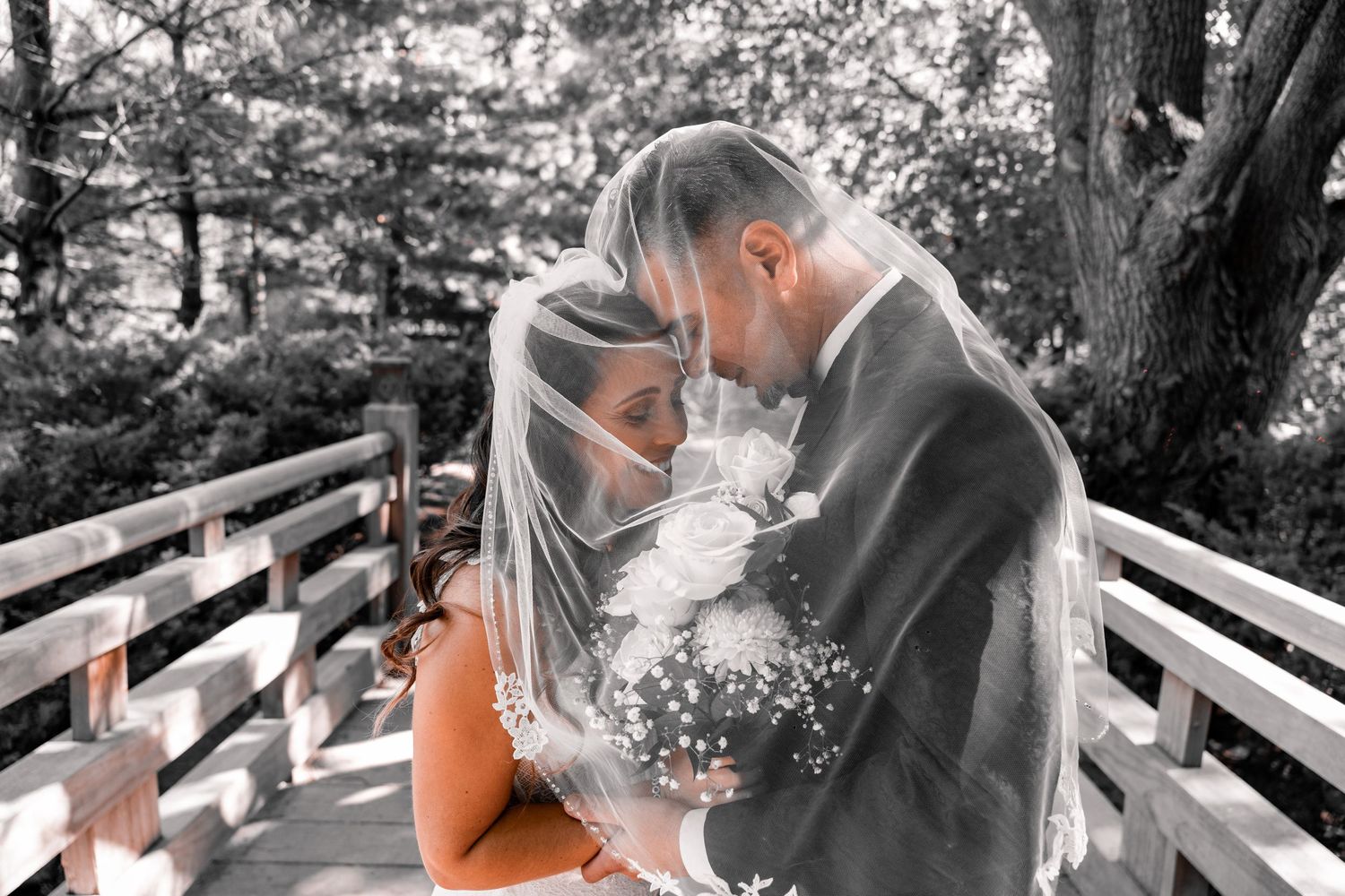 Black and white photo series of a couple sharing romantic moments on outdoor wooden stairs in a garden setting.