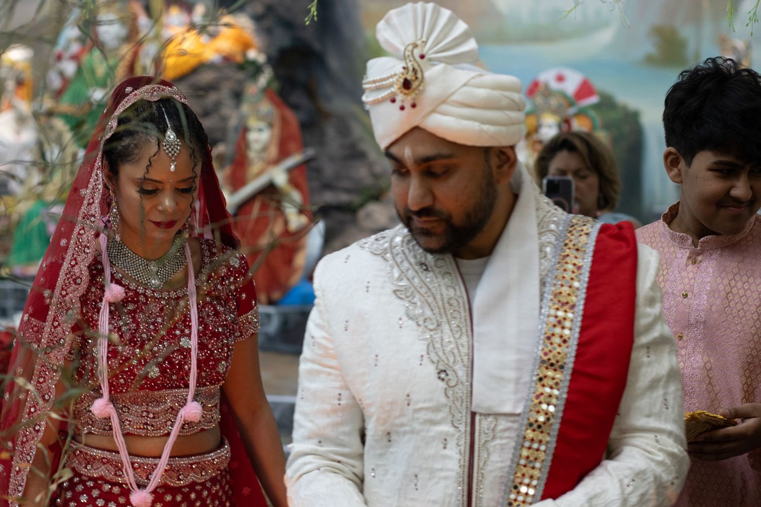 Wedding guests watch as a couple performs traditional Indian marriage rituals.