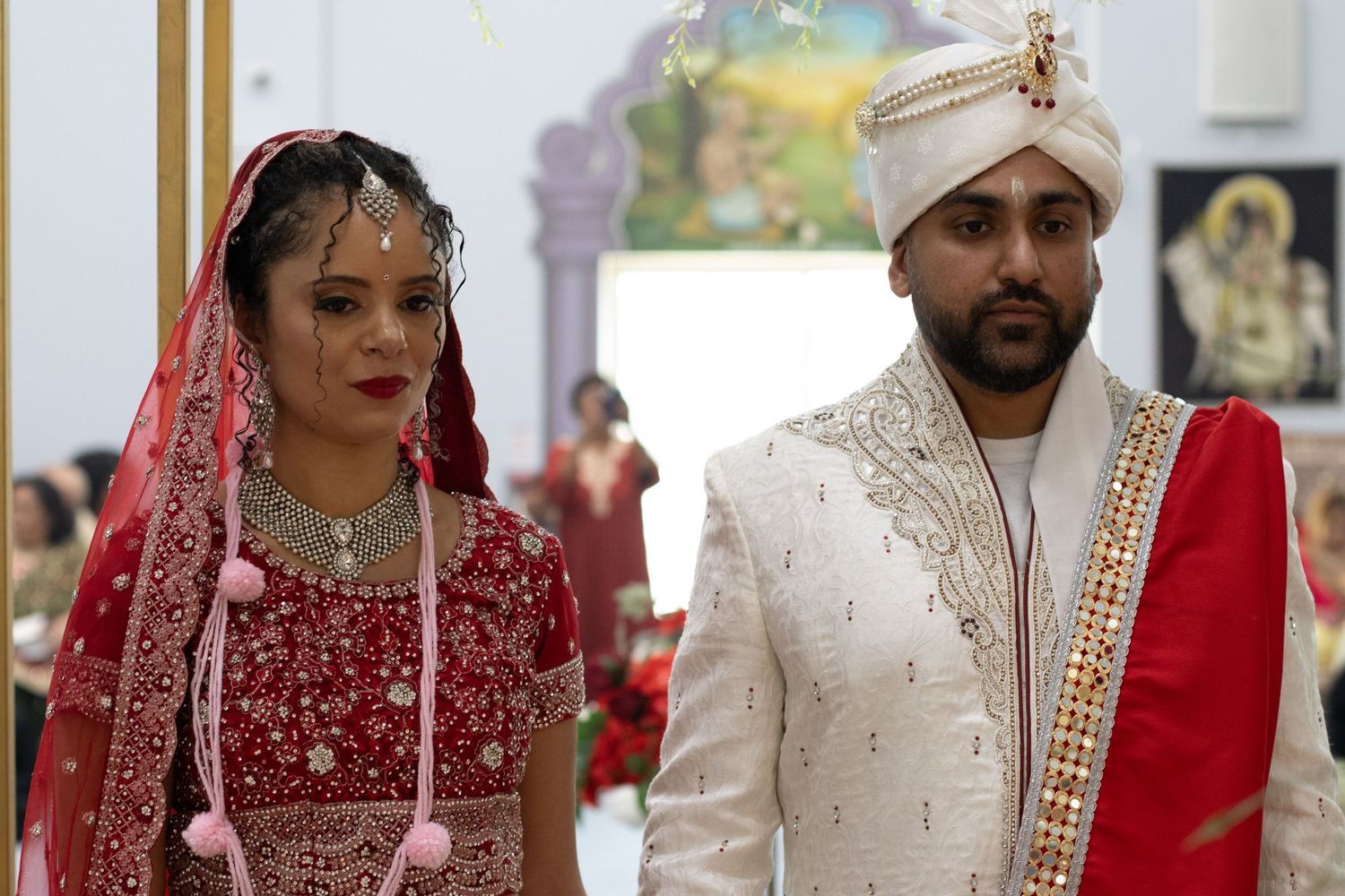Traditional Indian wedding ceremony with couple in ornate red and white attire.