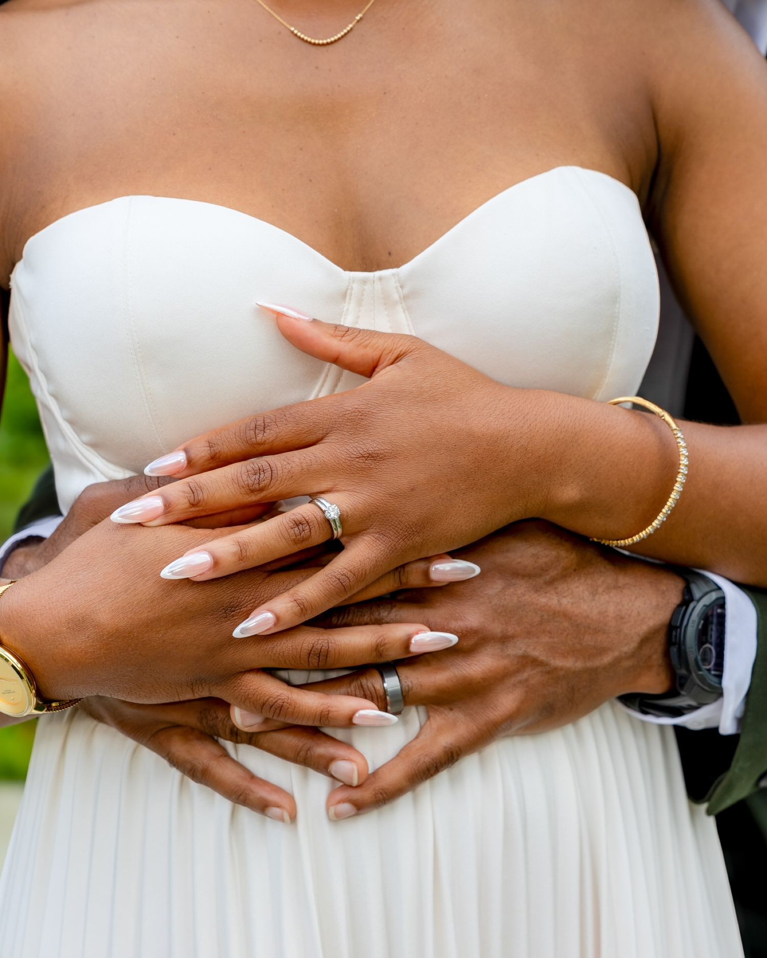 Close-up series of hands embracing around waist showing wedding rings and white dress details.