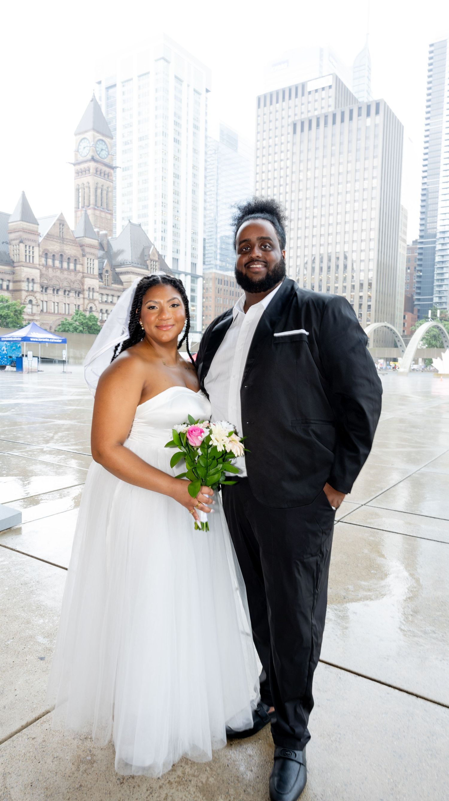 Wedding photos captured against Toronto's iconic cityscape with modern architecture in background.