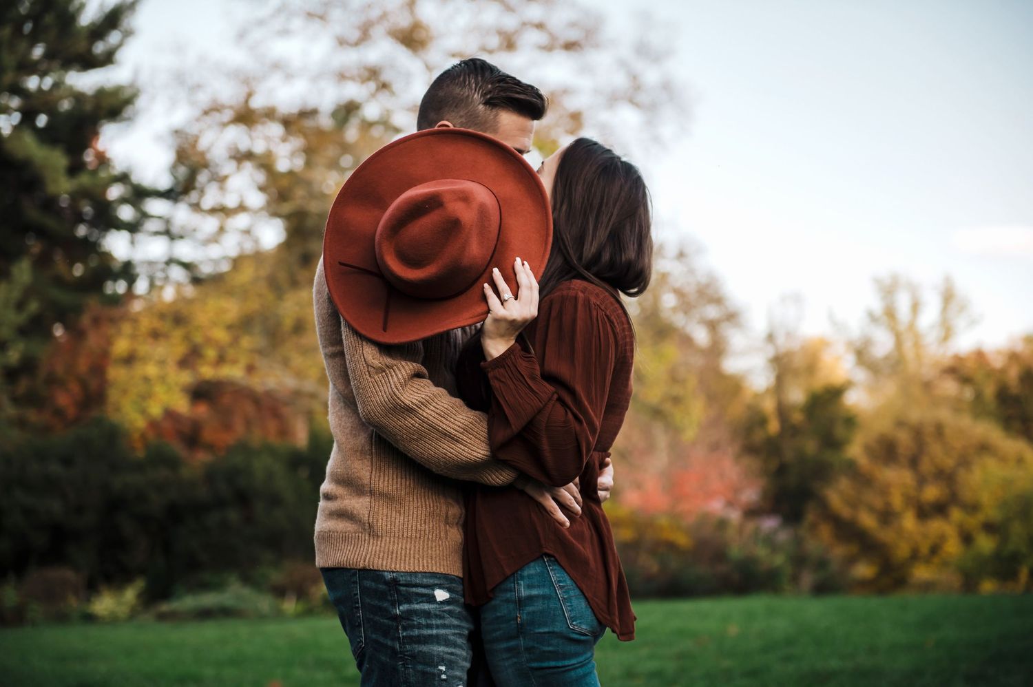 Couple embracing outdoors in casual fall attire.