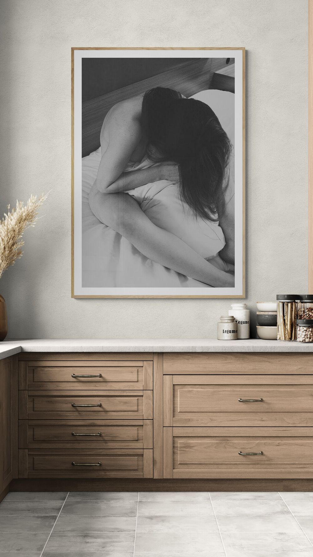 Modern interior with wooden drawers and artistic black and white photography framed on gray wall.