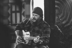 Black and white portraits of musicians playing acoustic guitars.