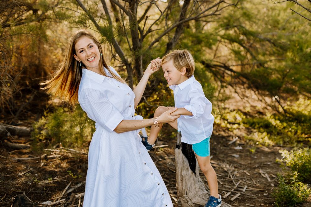 Rafa holds his mother's hands as they both laugh during the spring family photoshoot.