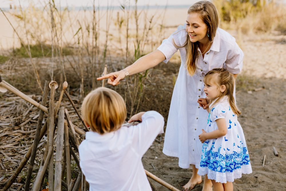 Mom and her children building a bamboo tipi tent at a Marbella family photoshoot.