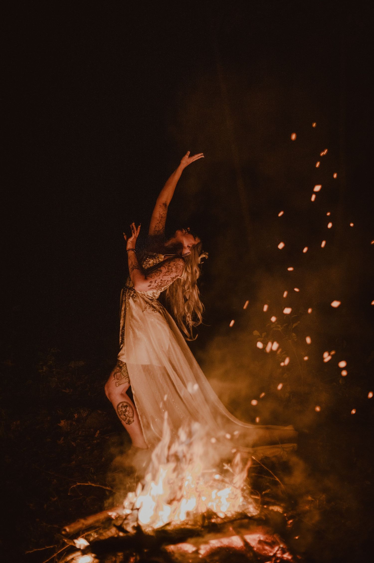 Bridal portrait around a fire. Stunning details in the wedding dress.
