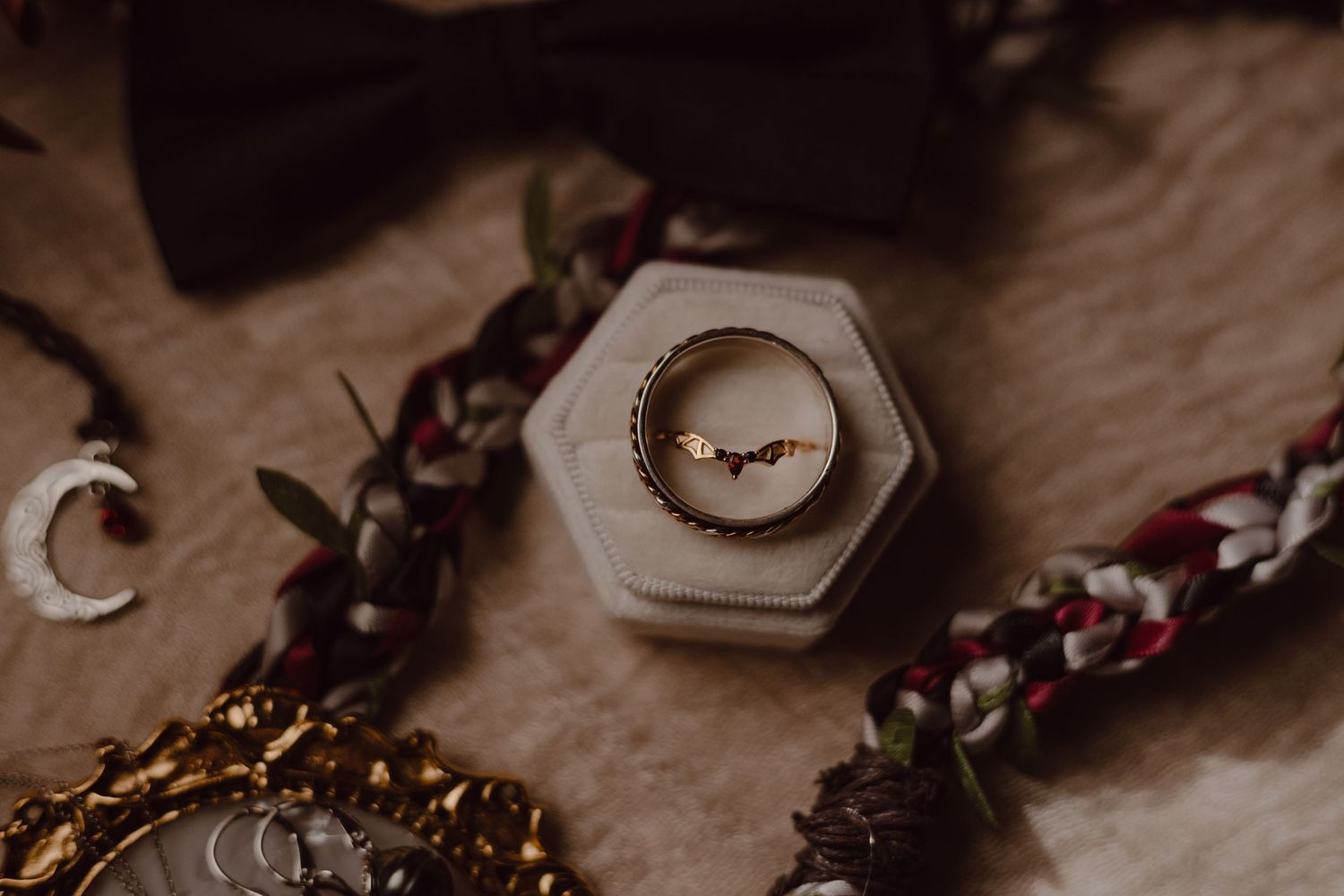 Detail shot of bride's gothic bat wedding ring from their flat lay.