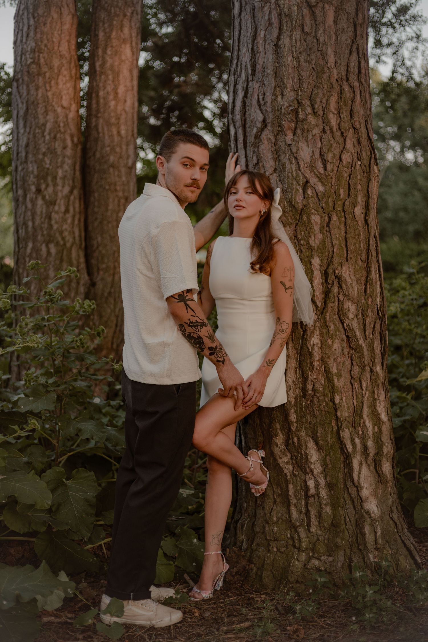 Bride and groom pose in front of a tree at Gage park in Hamilton, Ontario for their elopement photos.