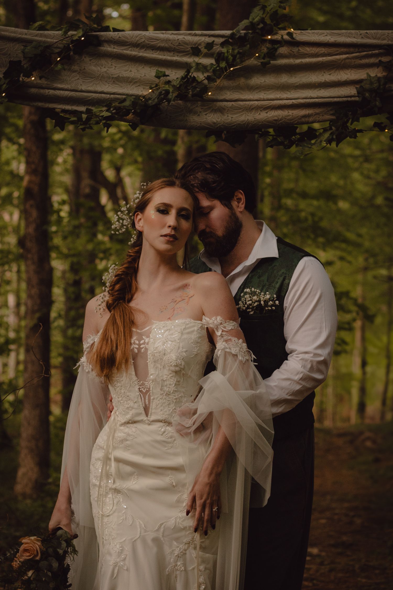 Moody portrait of bride and groom during their elopement portraits in the woods.