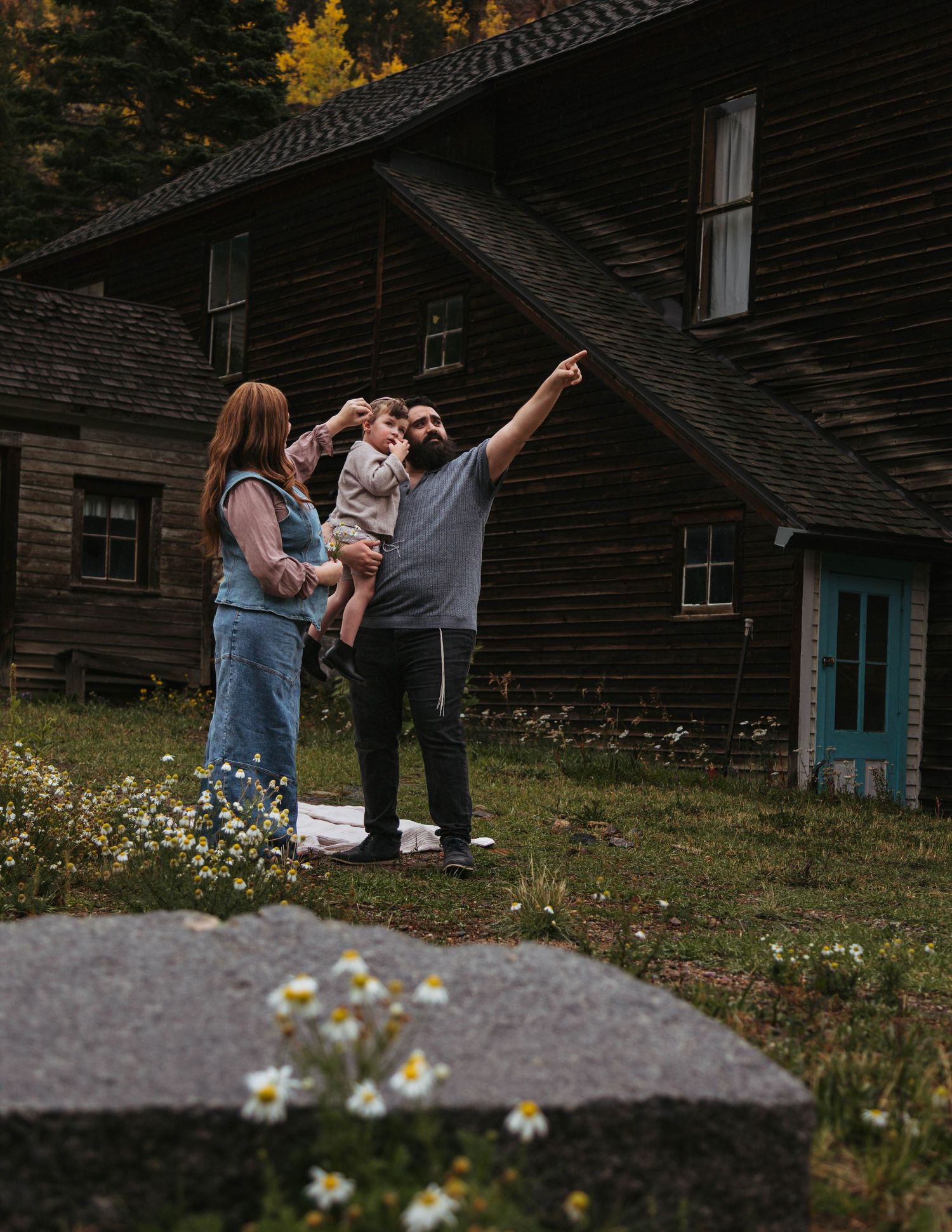 Family group poses together on a wooden bridge during an outdoor photo session.