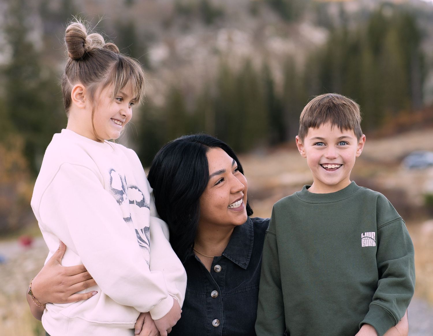 Mom embracing her children in scenic Tony's Grove, Bear Lake, UT, during a photo family session.