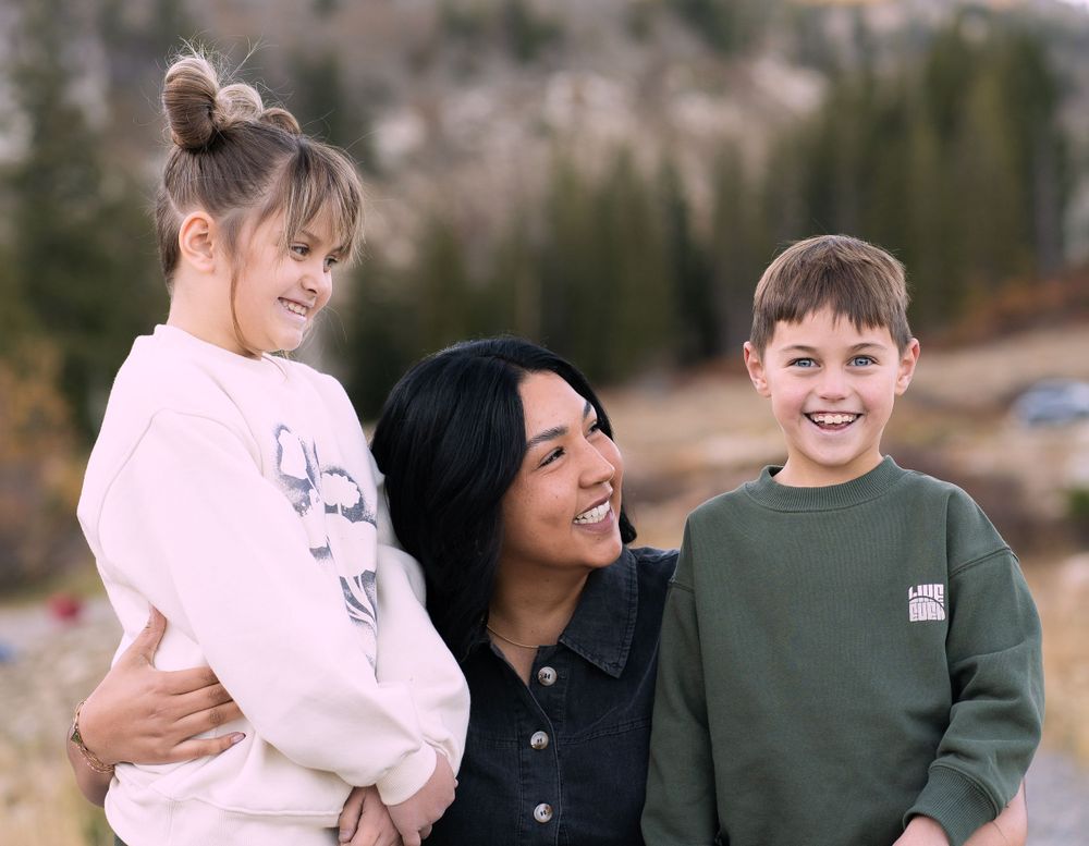 Mom embracing her children in scenic Tony's Grove, Bear Lake, UT, during a photo family session.