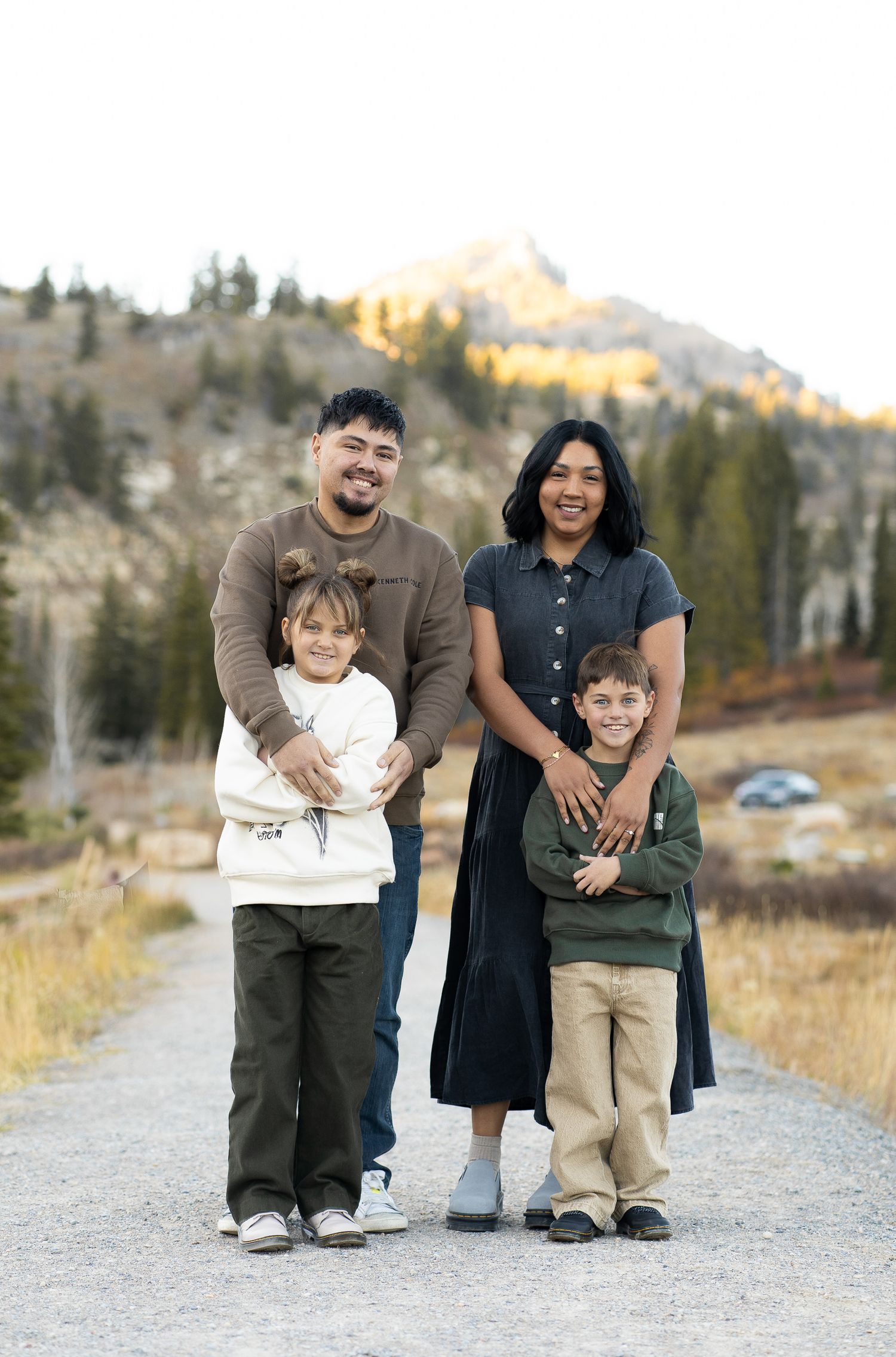 Family embracing in scenic Tony's Grove, Bear Lake, UT, during a photo session.