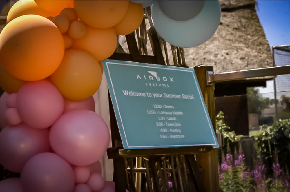 Decorative balloon arch in pastel colors against outdoor venue backdrop.
