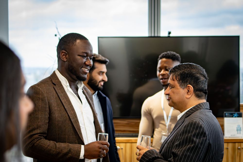 Business professionals engaged in animated conversation at a networking event.