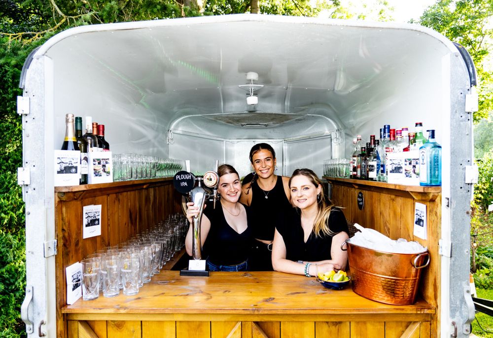 Interior view of a mobile bar serving station with wooden counter and equipment.