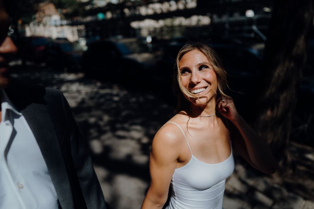 A joyful moment captured in dappled sunlight during an outdoor celebration.